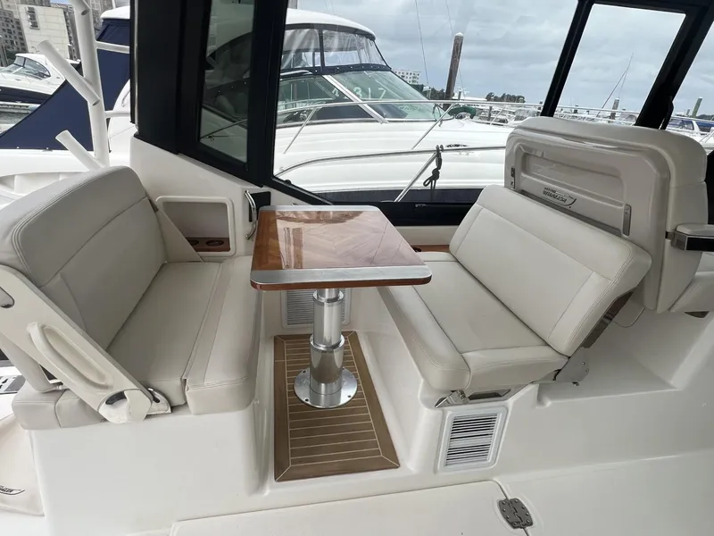 Slide: The Image of Boston Whaler 405 Conquest 2021 interior seating with table, docked at marina. - 25