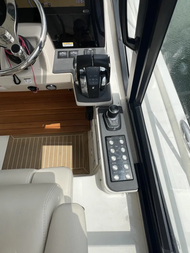 Slide: The Image of 2021 Boston Whaler 405 Conquest helm with controls and steering wheel, featuring modern design. - 31