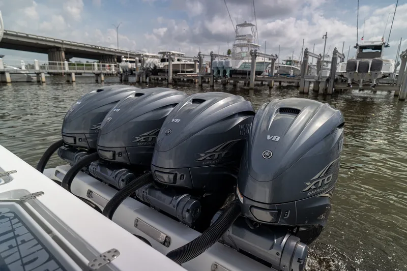 Slide: The Image of Four Yamaha XTO V8 outboard engines on a 2023 Contender 44 ST boat at a marina. - 15