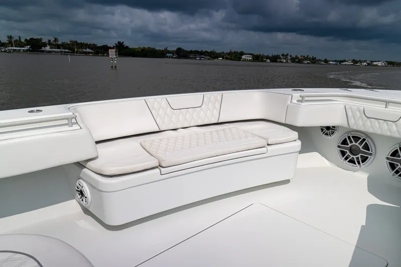 Slide: The Image of Luxurious seating on 2023 Contender 44 ST boat, featuring elegant white upholstery and scenic water backdrop. - 21