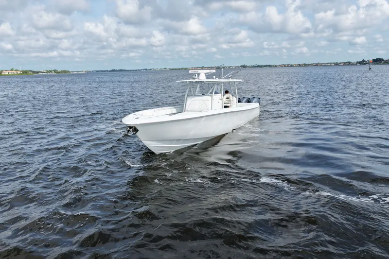 Slide: The Image of 2023 Contender 44 ST boat cruising on open water under a cloudy sky. - 24