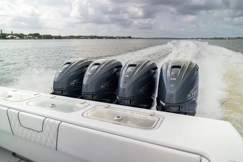 Slide: The Image of 2023 Contender 44 ST boat with four powerful outboard engines cruising on open water. - 29