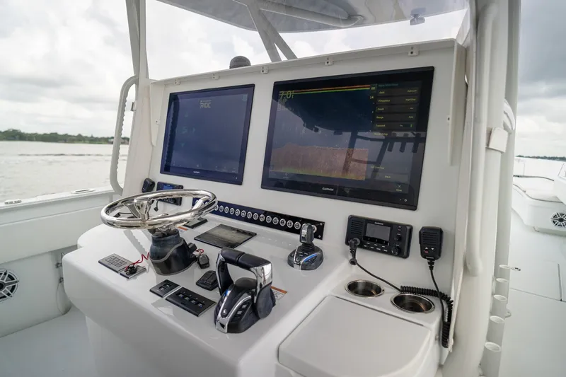 Slide: The Image of 2023 Contender 44 ST boat dashboard with dual screens and navigation controls. - 31