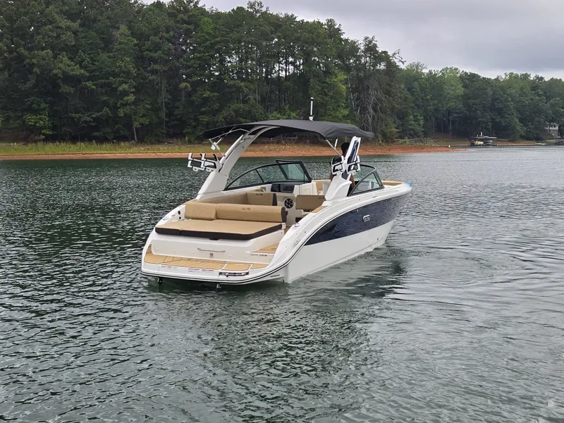 Slide: The Image of A 2027 Sea Ray SDX 270 Surf on a calm lake, surrounded by trees. - 5