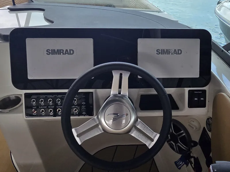 Slide: The Image of The image shows the helm of a Sea Ray SDX 270 Surf with Simrad screens. - 17