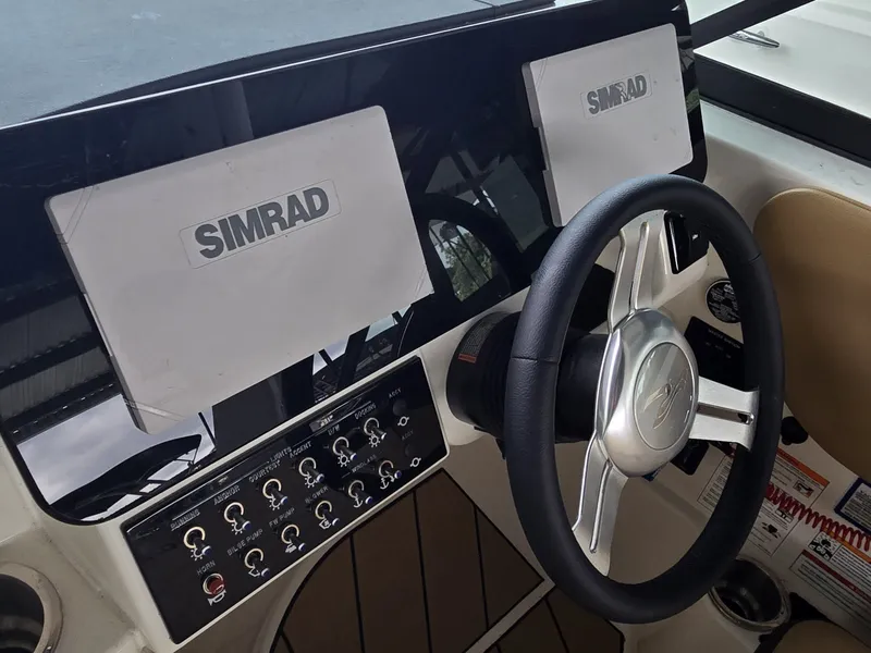 Slide: The Image of The image shows the helm of a Sea Ray SDX 270 Surf with Simrad screens. - 16