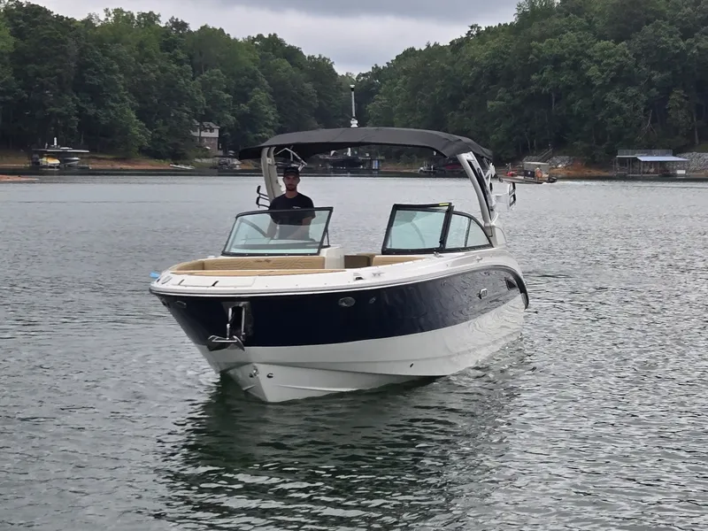 Slide: The Image of A 2027 Sea Ray SDX 270 Surf on a calm lake, surrounded by trees. - 32