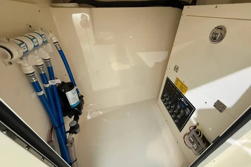 Slide: The Image of Interior view of 2026 Scout 240 Dorado boat's utility compartment with control panel and plumbing. - 6