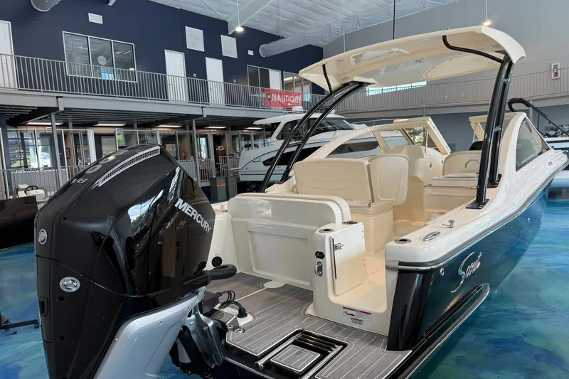 Slide: The Image of 2026 Scout 240 Dorado boat with Mercury engine in showroom setting. - 3