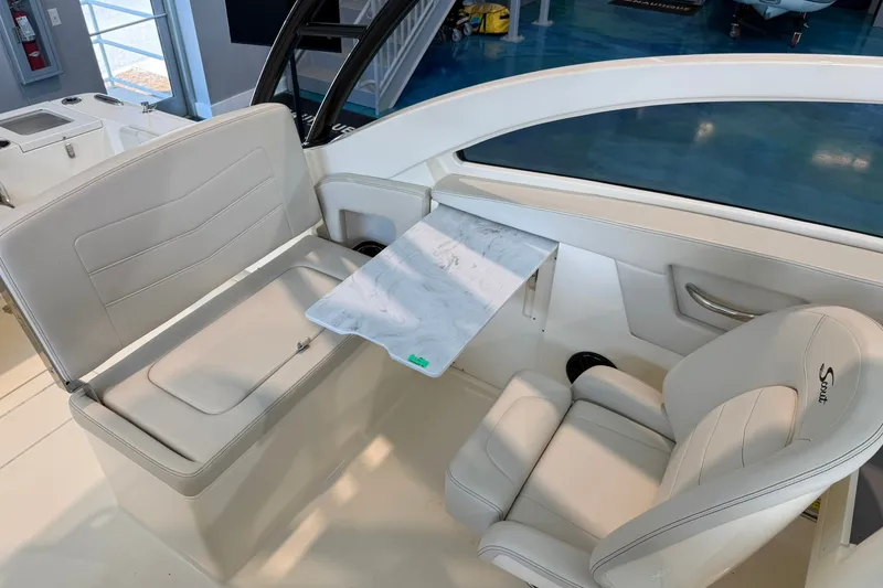 Slide: The Image of 2026 Scout 240 Dorado boat interior with white seating and a foldable table. - 12