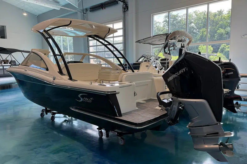Slide: The Image of 2026 Scout 240 Dorado boat with Mercury engine displayed indoors. - 2