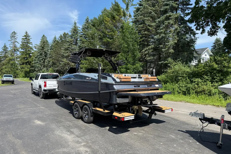 Slide: The Image of 2025 Varatti Z2373 boat on trailer, parked near lush greenery and trees. - 8