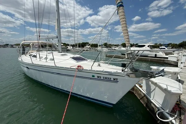 Slide: The Image of 2005 Catalina 400 sailboat docked in marina under blue sky with clouds. - 3
