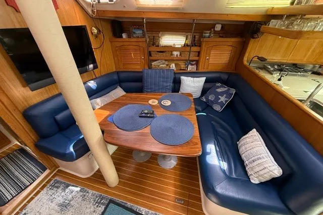 Slide: The Image of Cozy interior of a 2005 Catalina 400 sailboat with blue seating and wooden table. - 45