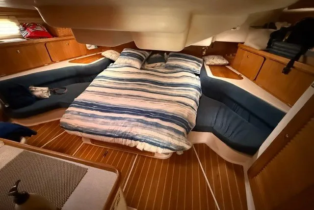 Slide: The Image of Cozy cabin interior of a 2005 Catalina 400 sailboat with a striped bedspread. - 51