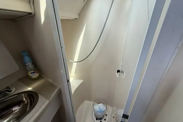 Slide: The Image of 2005 Catalina 400 yacht bathroom with sink, shower, and cleaning supplies. - 56