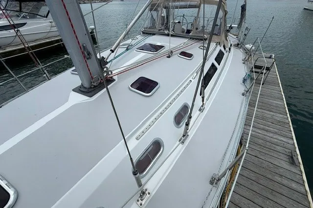 Slide: The Image of 2005 Catalina 400 sailboat docked, showcasing deck and cabin features. - 10