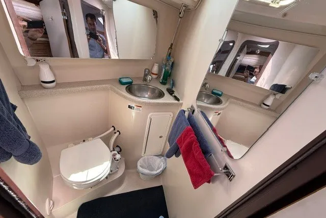 Slide: The Image of Bathroom interior of a 2005 Catalina 400 yacht, featuring sink, toilet, and mirrors. - 50