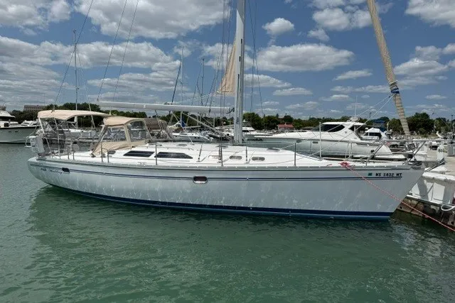 The Image of 2005 Catalina 400 sailboat docked in a marina under a partly cloudy sky. - 0