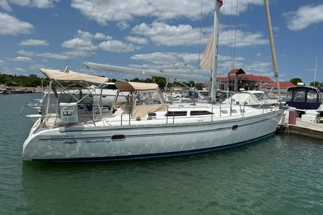 Slide: The Image of 2005 Catalina 400 sailboat docked in a marina under a clear blue sky. - 1
