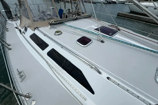 Slide: The Image of 2005 Catalina 400 sailboat deck with hatches and rigging in marina setting. - 15