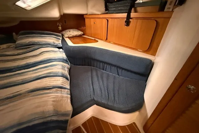 Slide: The Image of Cozy cabin interior of 2005 Catalina 400 sailboat with striped bedding and wooden cabinetry. - 52