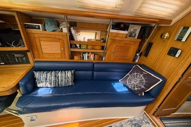 Slide: The Image of Interior of a 2005 Catalina 400 yacht with blue leather seating and wooden cabinetry. - 47