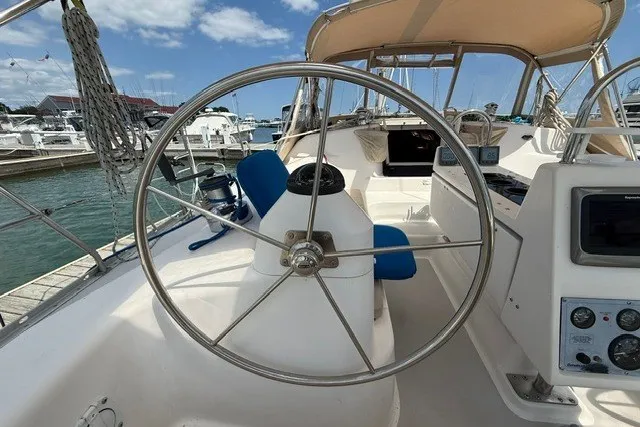 Slide: The Image of 2005 Catalina 400 sailboat cockpit with steering wheel, marina background, and clear sky. - 25