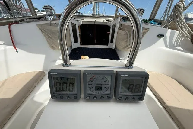 Slide: The Image of Cockpit of 2005 Catalina 400 sailboat with navigation instruments and open cabin doors. - 34