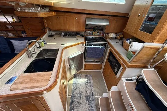 Slide: The Image of Interior of a 2005 Catalina 400 yacht kitchen with wooden cabinetry and modern appliances. - 38