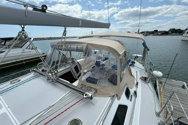 Slide: The Image of 2005 Catalina 400 sailboat docked at marina under a partly cloudy sky. - 11