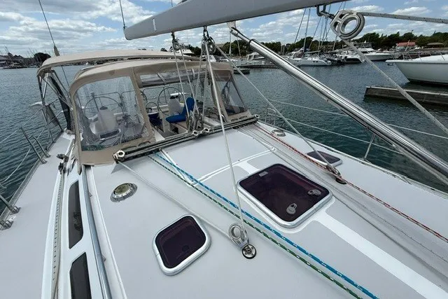 Slide: The Image of 2005 Catalina 400 sailboat deck with rigging, docked in a marina under cloudy skies. - 16