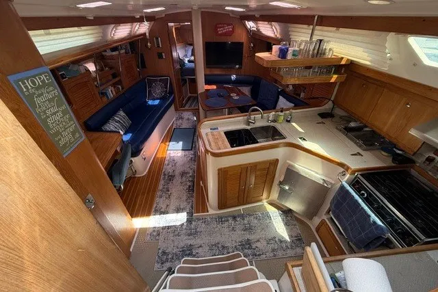 Slide: The Image of Interior of a 2005 Catalina 400 sailboat featuring a cozy kitchen and seating area. - 37