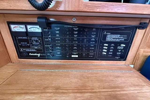 Slide: The Image of Control panel of a 2005 Catalina 400 yacht with various switches and gauges. - 43