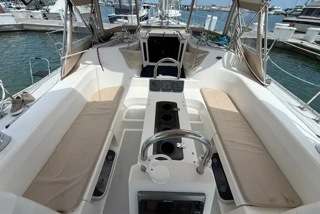 Slide: The Image of 2005 Catalina 400 sailboat cockpit with beige seating and steering wheel, docked at marina. - 33