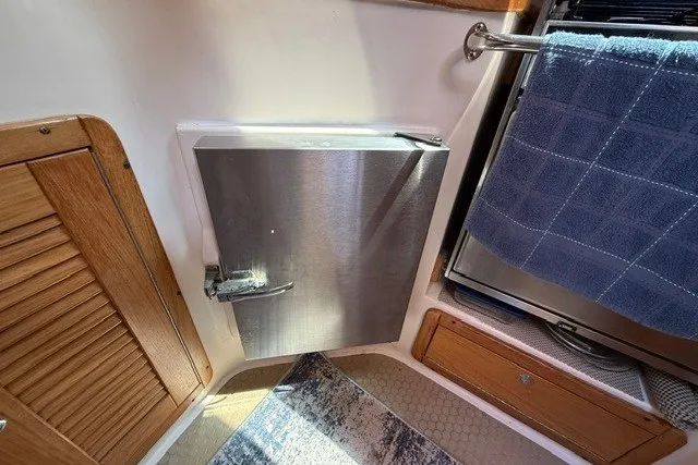Slide: The Image of Interior of a 2005 Catalina 400 yacht, featuring a compact kitchen area. - 41