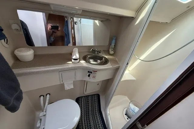 Slide: The Image of Compact bathroom in a 2005 Catalina 400 yacht, featuring a toilet, sink, and mirror. - 55