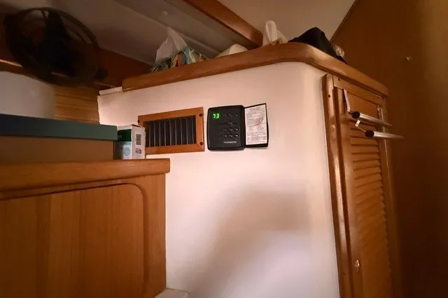 Slide: The Image of Interior of a 2005 Catalina 400 yacht with wooden cabinetry and digital thermostat. - 54