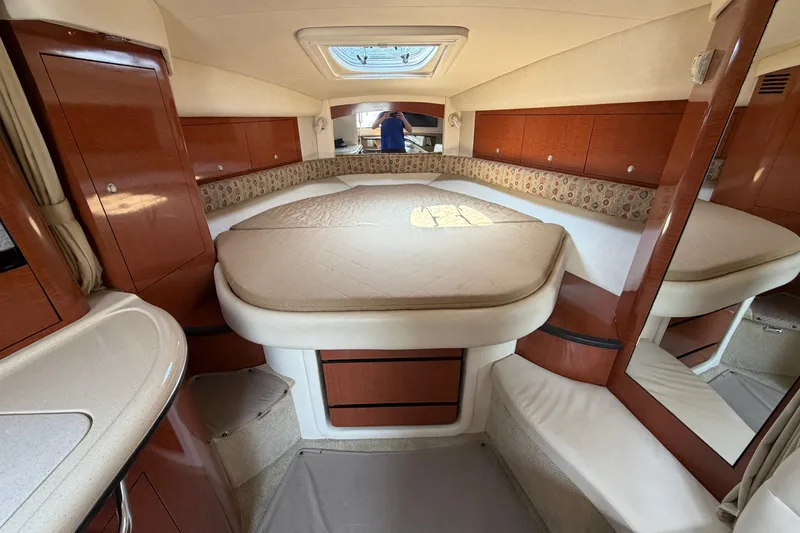 Slide: The Image of Interior cabin of a 2005 Sea Ray 340 Sundancer yacht, featuring a cozy bed and wooden cabinetry. - 13