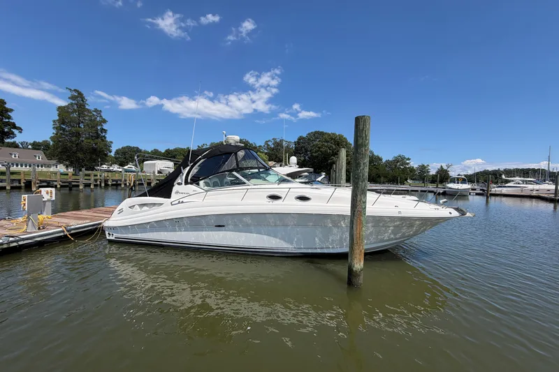 Slide: The Image of 2005 Sea Ray 340 Sundancer docked at a marina under a clear blue sky. - 1