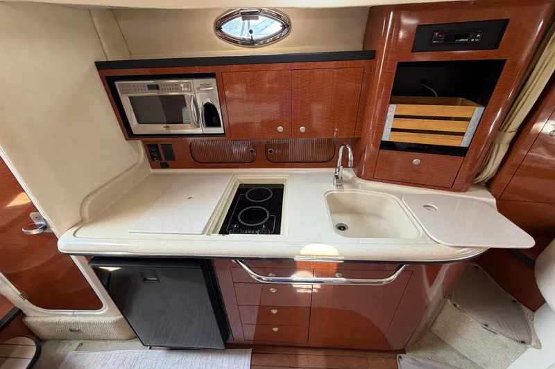 Slide: The Image of Luxurious 2005 Sea Ray 340 Sundancer yacht kitchen with modern appliances and elegant wood finish. - 16
