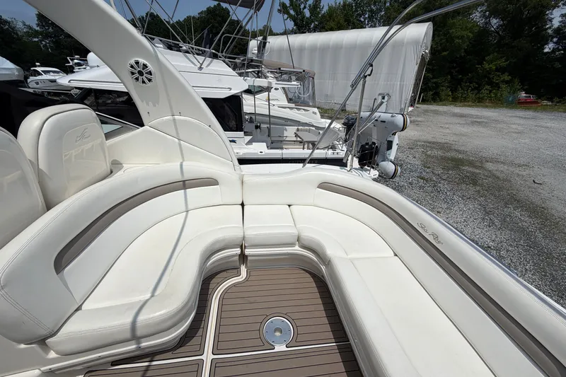 Slide: The Image of 2005 Sea Ray 340 Sundancer boat with white seating and teak flooring in a marina. - 18