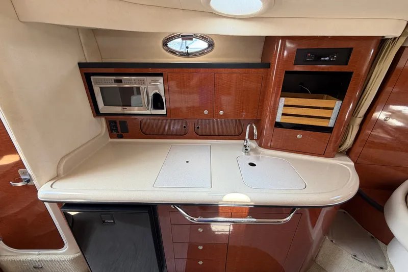 Slide: The Image of 2005 Sea Ray 340 Sundancer galley with microwave, sink, and storage cabinets. - 17