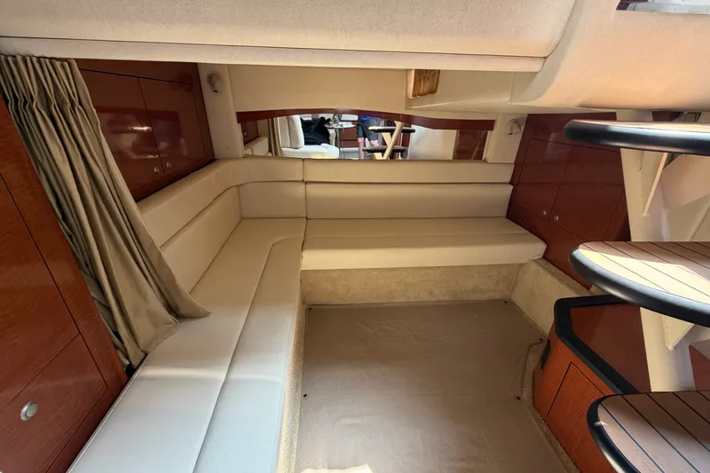 Slide: The Image of Interior of 2005 Sea Ray 340 Sundancer yacht with beige seating and wooden accents. - 14