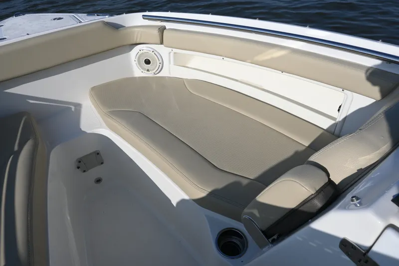 Slide: The Image of 2021 Pursuit DC 266 Dual Console boat interior with beige seating and speaker. - 17