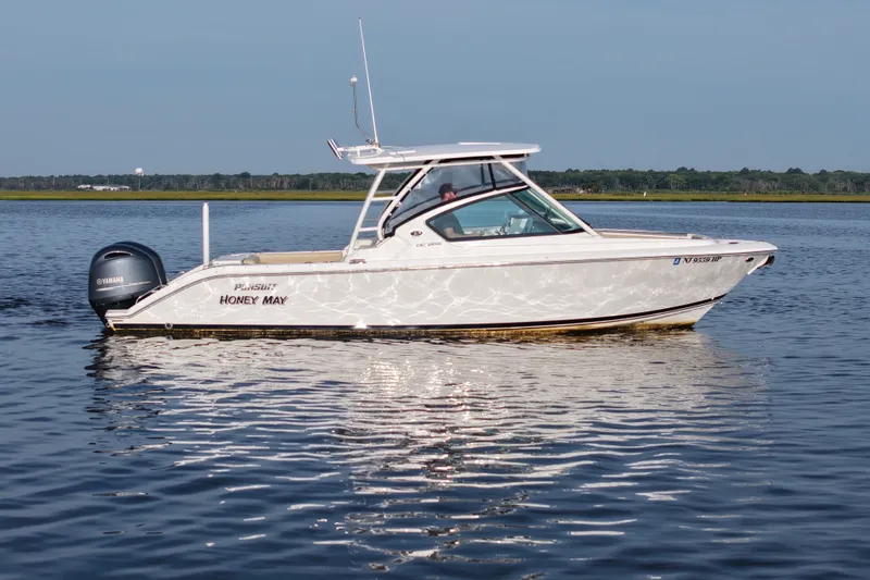 The Image of 2021 Pursuit DC 266 Dual Console boat on calm water, side view. - 0