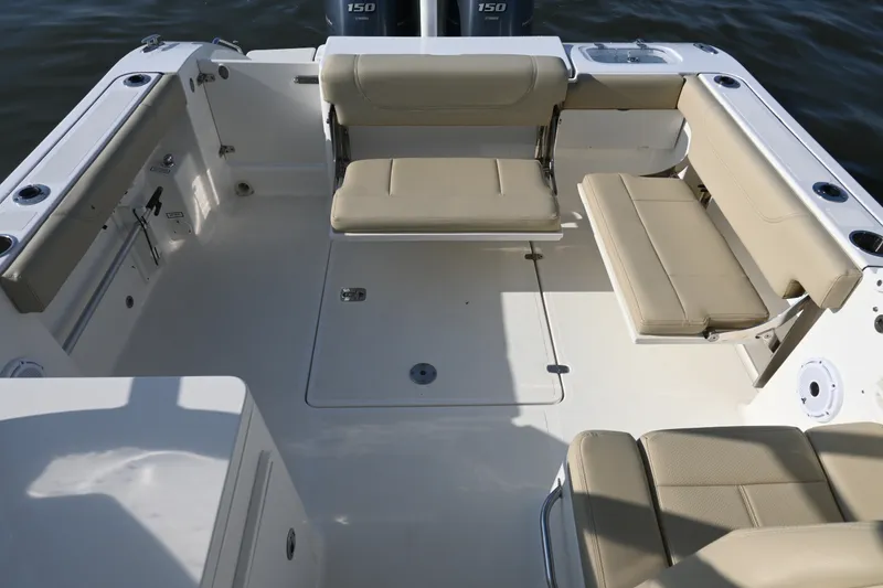 Slide: The Image of 2021 Pursuit DC 266 Dual Console boat interior with beige seating and spacious deck. - 28