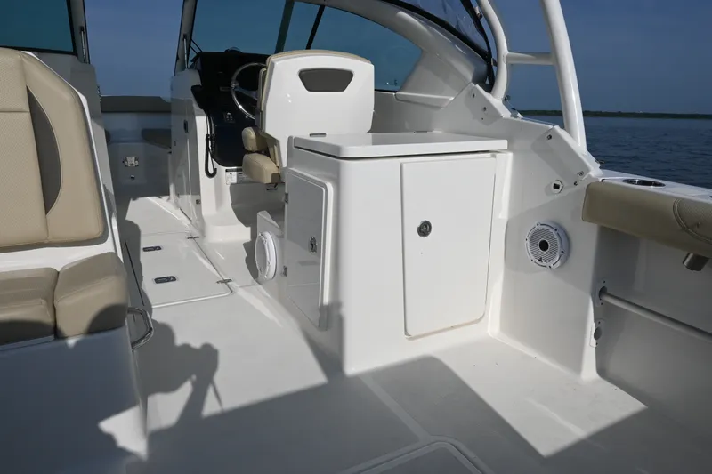 Slide: The Image of 2021 Pursuit DC 266 Dual Console boat interior with seating and helm, on calm water. - 26