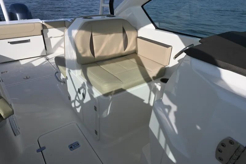 Slide: The Image of 2021 Pursuit DC 266 Dual Console boat interior with beige seating and water view. - 22