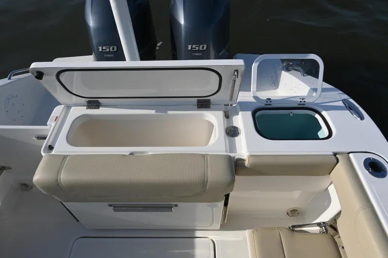 Slide: The Image of 2021 Pursuit DC 266 Dual Console boat with open storage compartments and twin Yamaha 150 engines. - 30